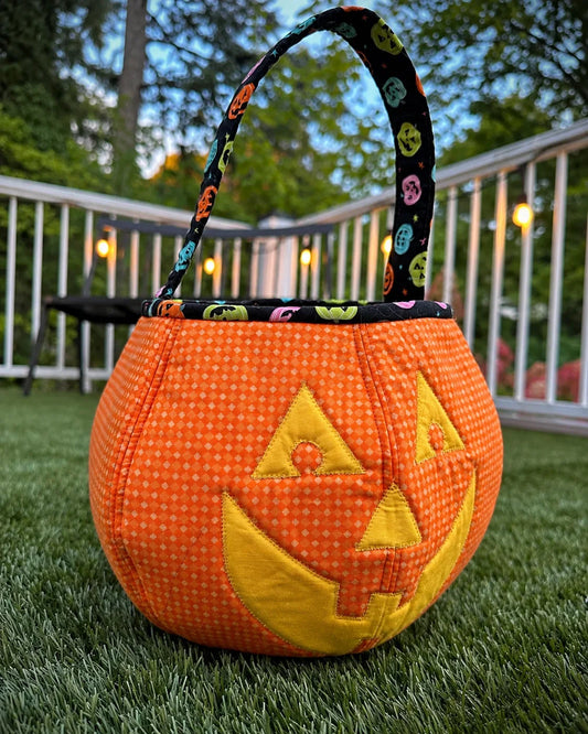 Quilted orange pumpkin candy bag with appliquéd face and fabric handle