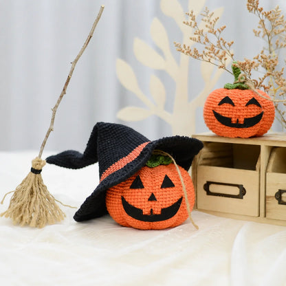 Crocheted pumpkin family on a shelf with autumn decorations