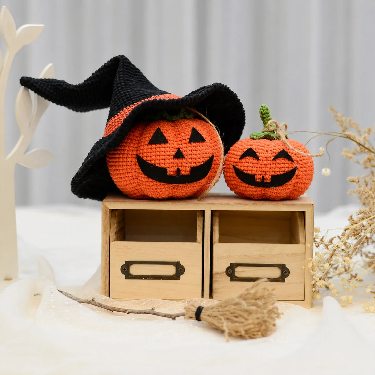 Hand-crocheted amigurumi pumpkins with green stems and leaves