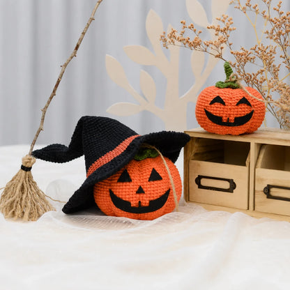 Finished amigurumi pumpkin held in hand to show size