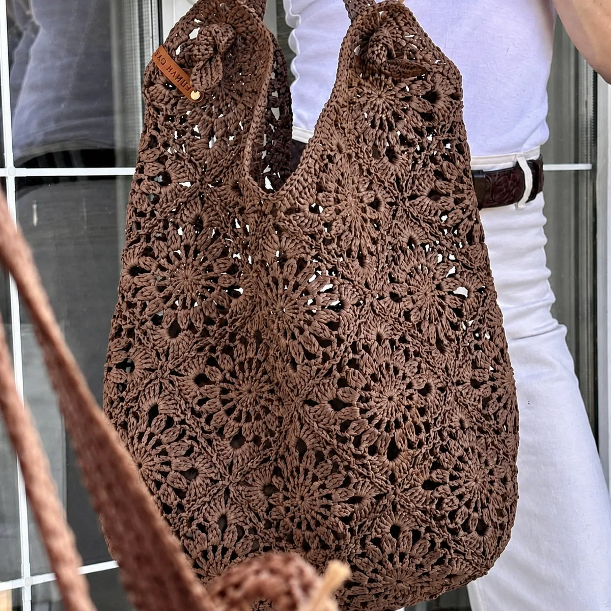 Raffia granny square crochet bag held in hand