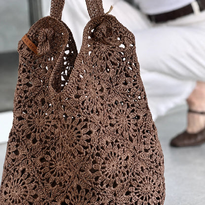 Woman carrying a crocheted raffia granny square bag