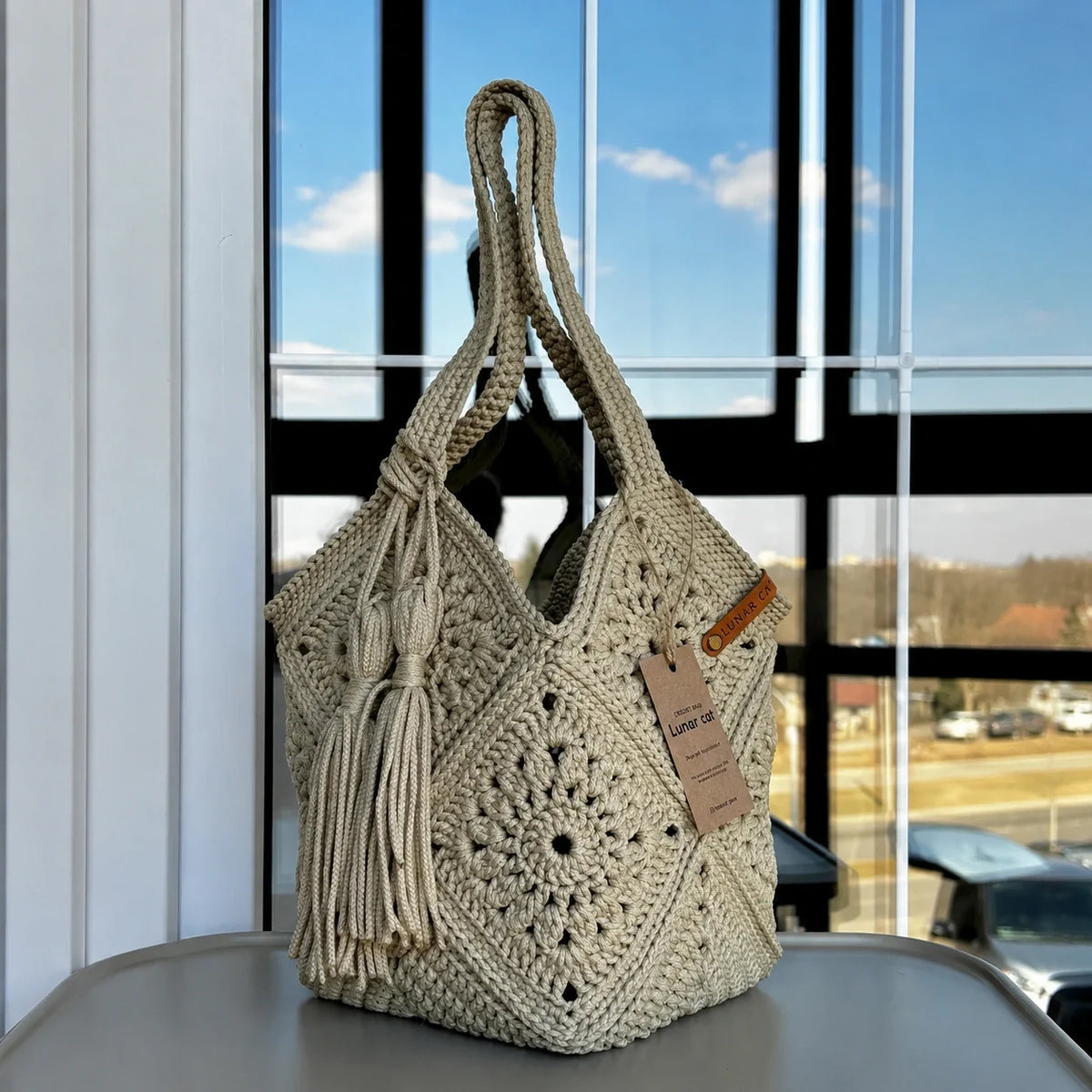 Crochet market bag held in hand at a farmers market