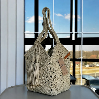 Crochet market bag held in hand at a farmers market