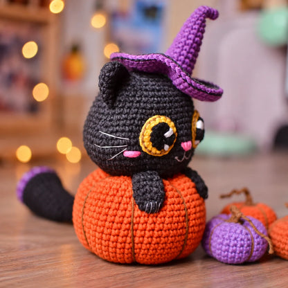 Amigurumi black cat in pumpkin Halloween decoration, front view