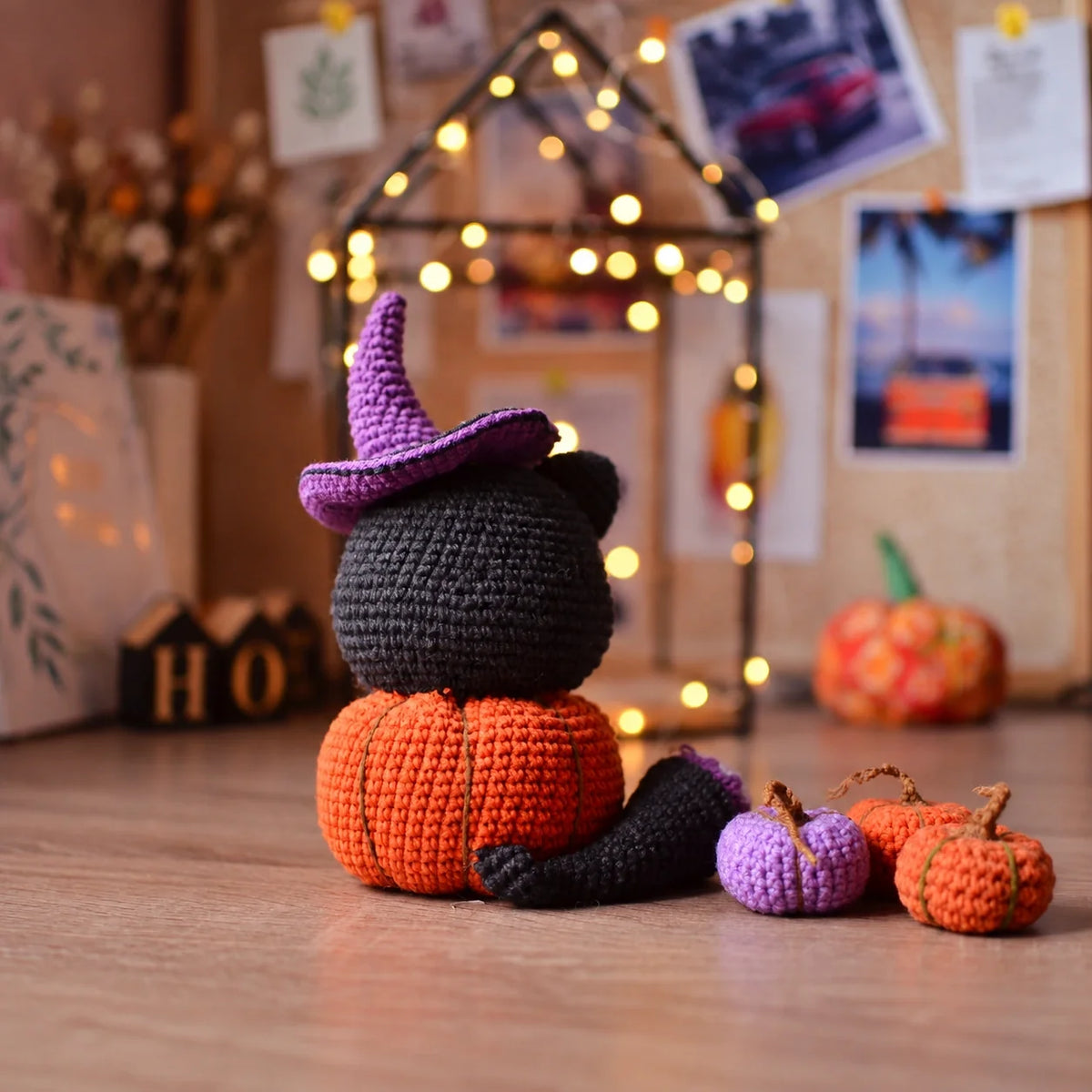 Crochet black cat in pumpkin with witch hat on a fall-themed background