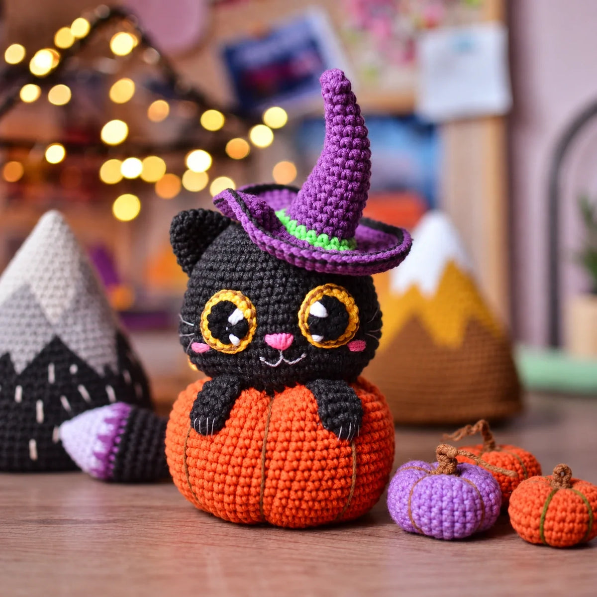 Handmade crocheted Halloween cat in pumpkin with purple witch hat