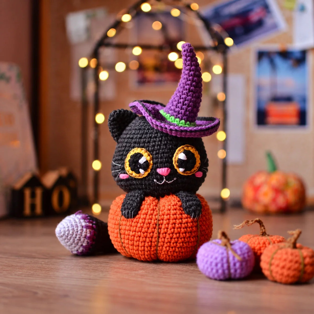 Close-up of the crocheted cat's face with big eyes and pink nose