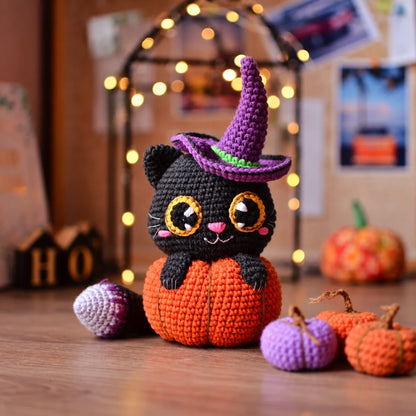Close-up of the crocheted cat's face with big eyes and pink nose