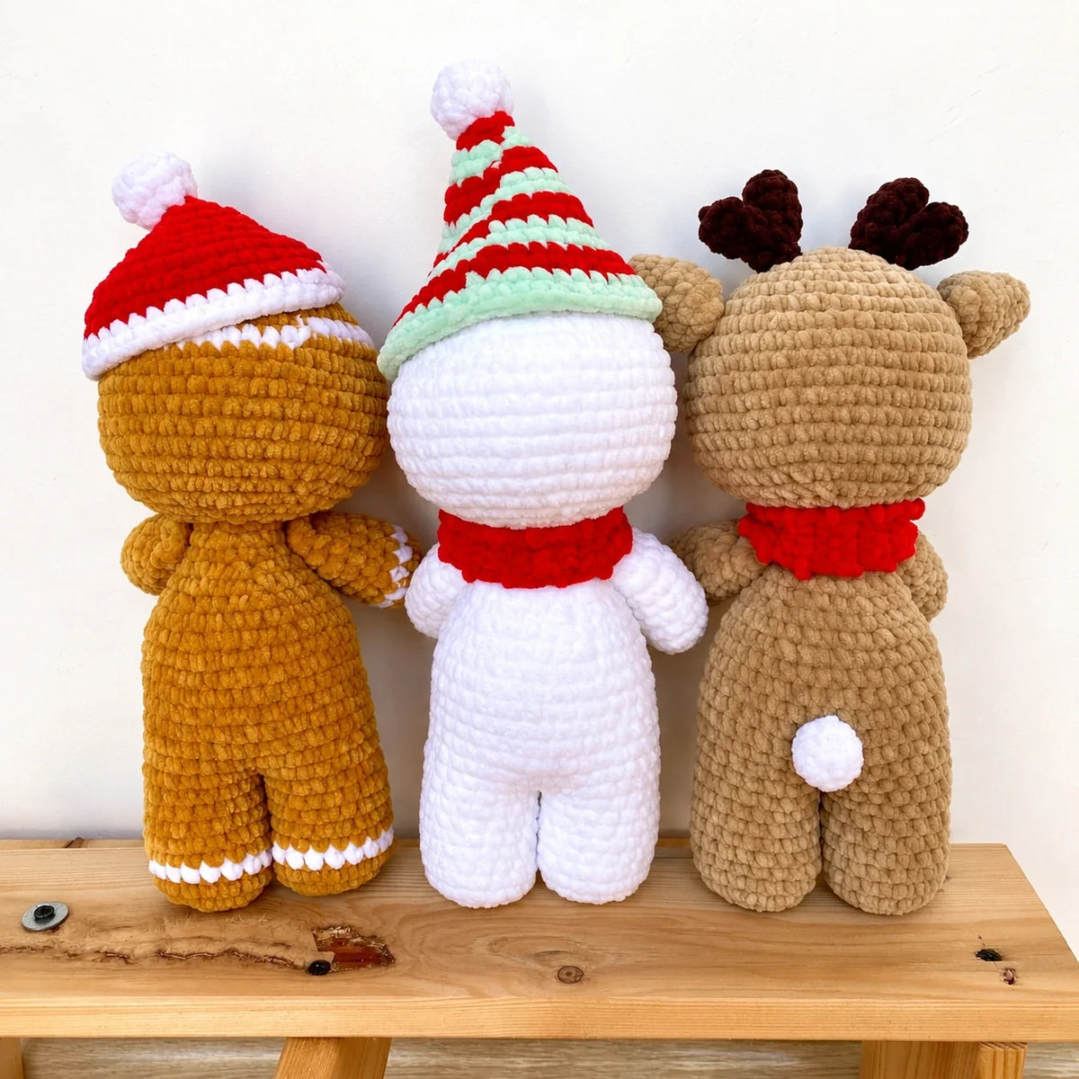 Crocheted gingerbread man and reindeer amigurumi under a Christmas tree