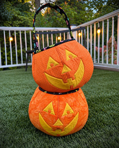 Two pumpkin trick-or-treat bags stacked, showing the patterned lining