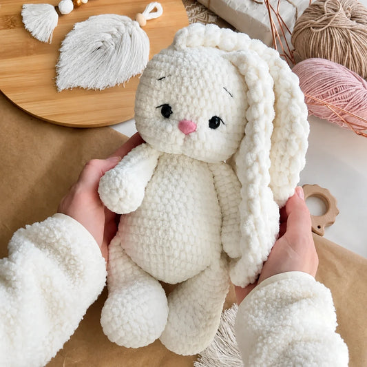 Crocheted plush bunny sitting upright, front view