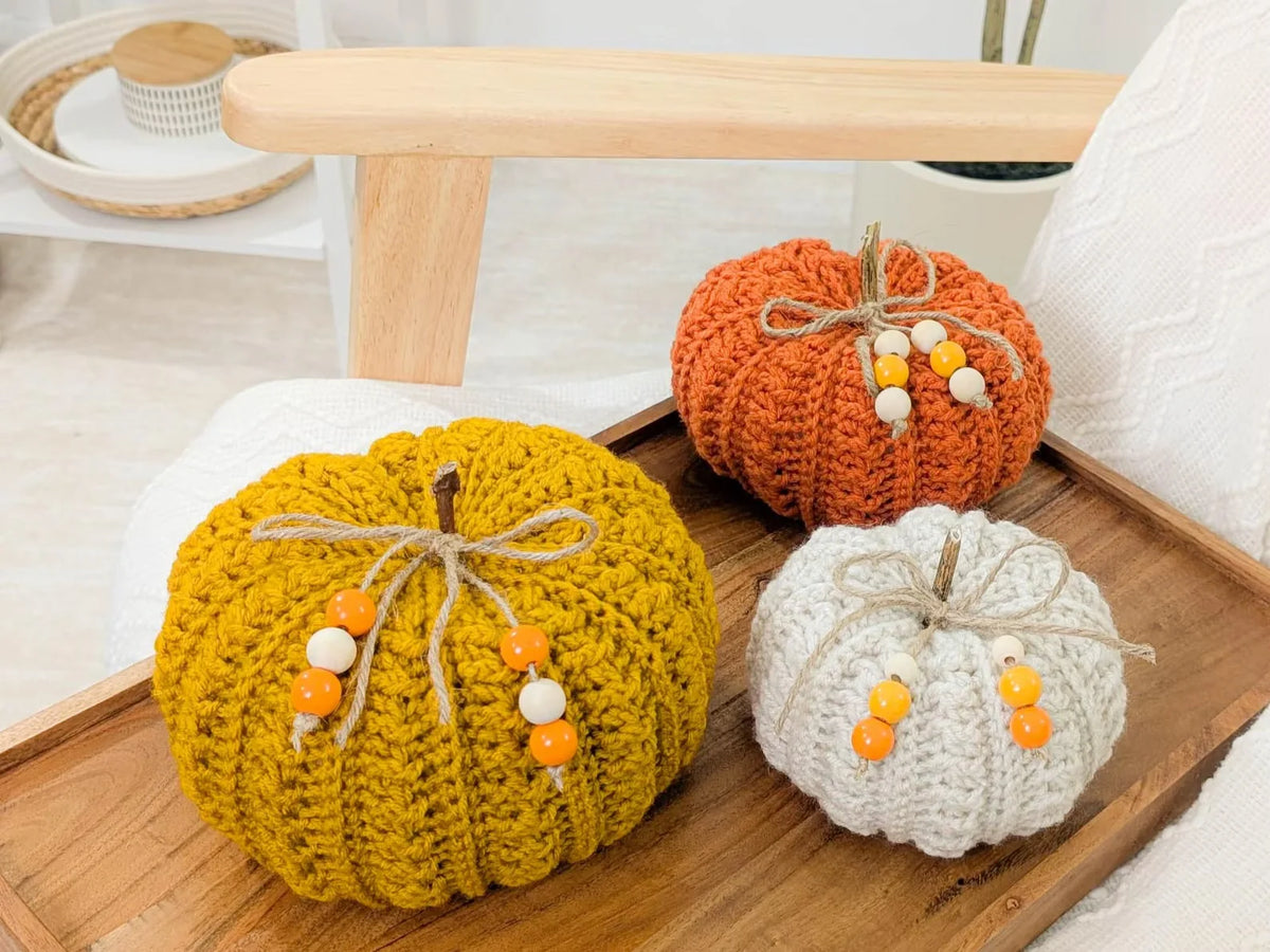 Handmade crocheted pumpkins displayed on a table