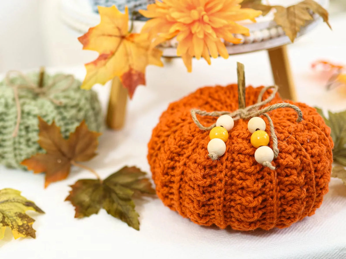 Crocheted pumpkins in orange, rust, and cream tones