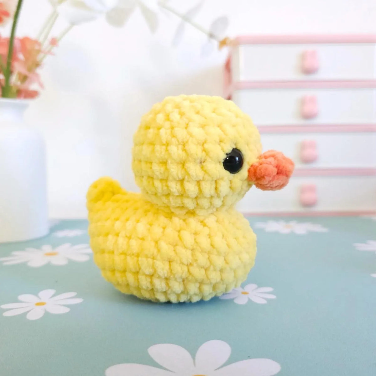 Small crocheted rubber duck held in a hand for size reference