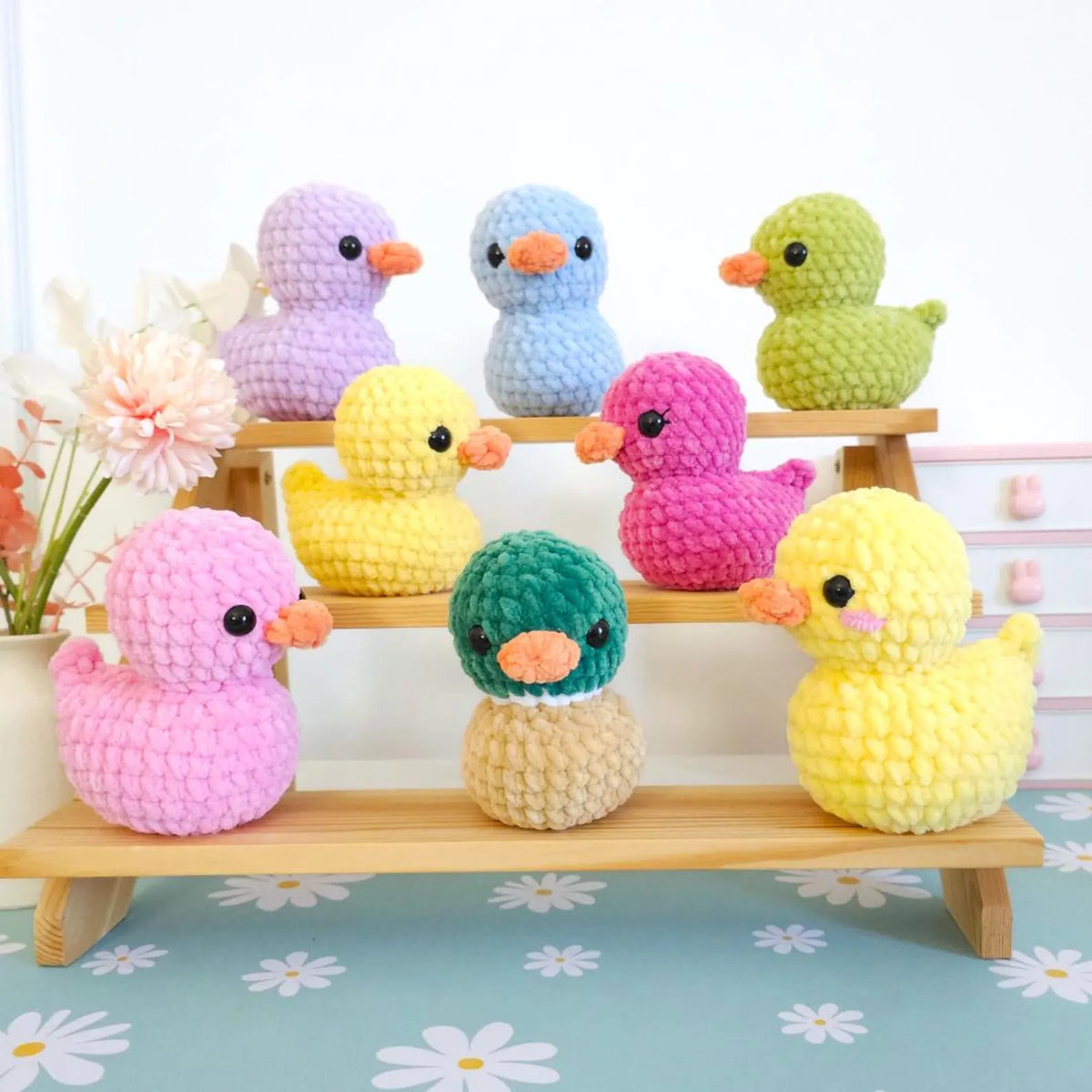 Blue and orange crochet ducklings side by side
