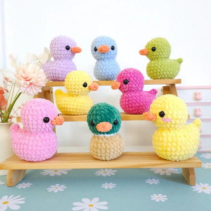 Blue and orange crochet ducklings side by side