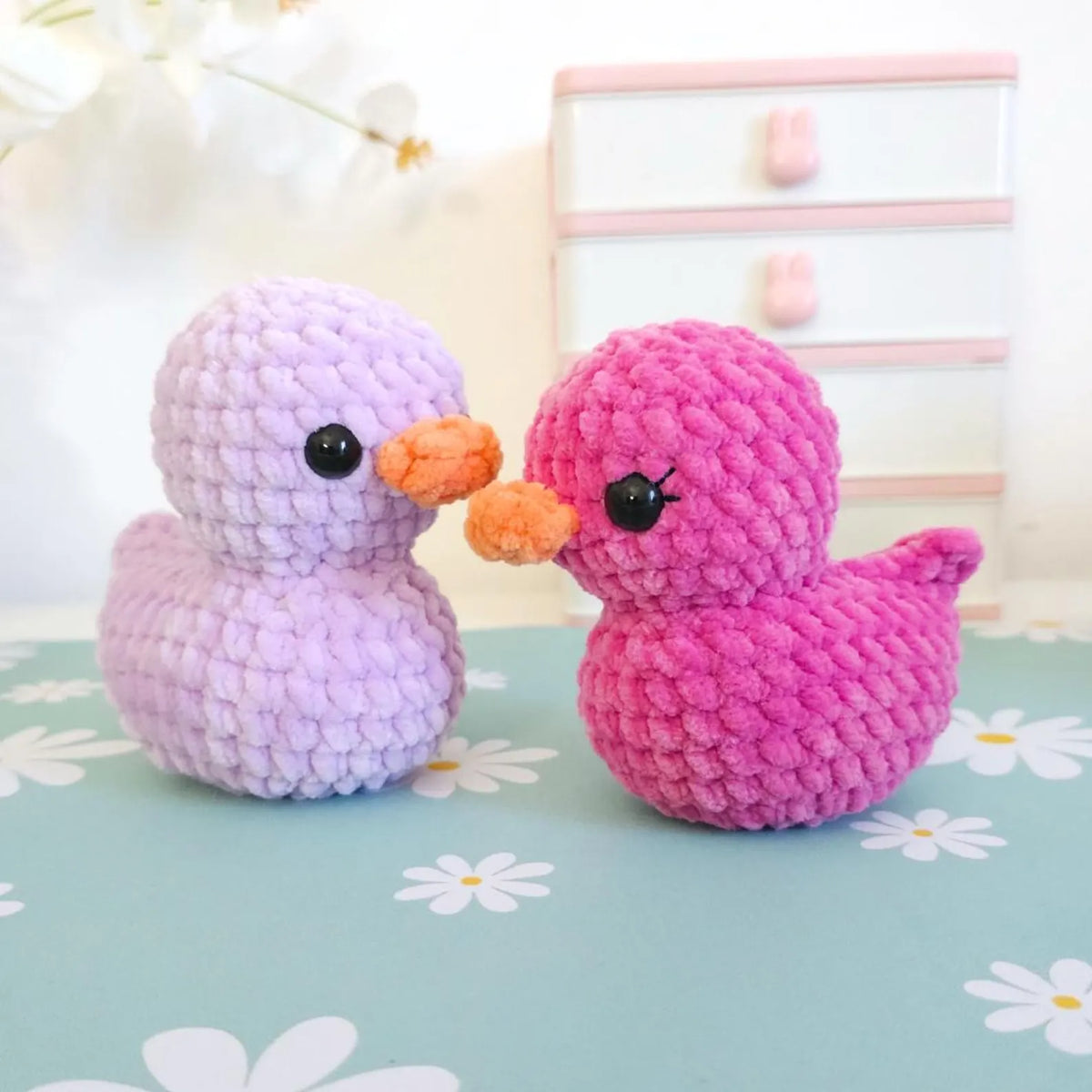Pastel crocheted ducklings lined up in a row