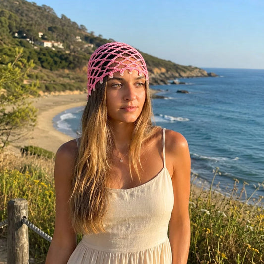 Pink crocheted hair net beanie with open mesh pattern